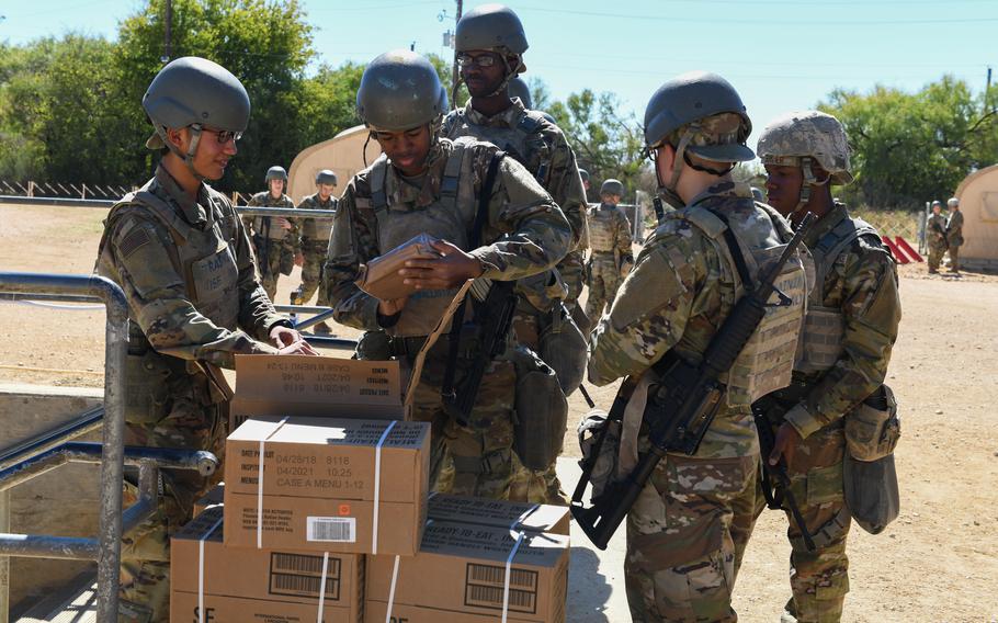 Airmen hand out Meals, Ready to Eat kits at Joint Base San Antonio-Chapman Training Annex in Texas on Oct. 26, 2022. They were among the first groups of airmen to go through PACER FORGE, the service's new field training conducted during basic military training.