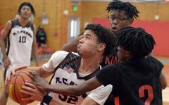 Matthew C. Perry's Roy Clayton is hemmed in by E.J. King's Jeremy Phillips and Keith Lombard during Saturday's DODEA-Japan basketball game. The Cobras rallied from a 12-point third-quarter deficit to win 72-59.