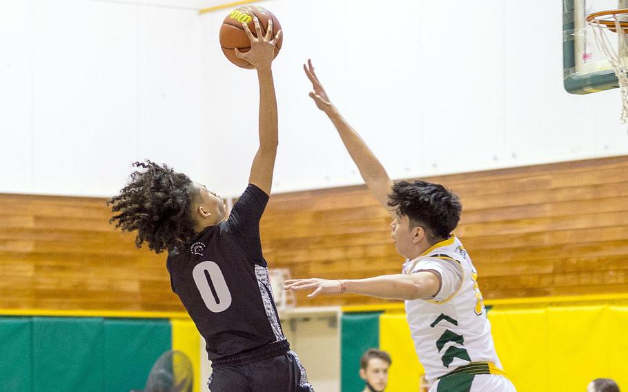 Zama's Jarius Brown shoots against Robert D. Edgren's Dennis Nelson during Friday's DODEA-Japan boys basketball game. The Trojans won 73-62.