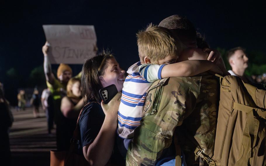 A child hugs an airman