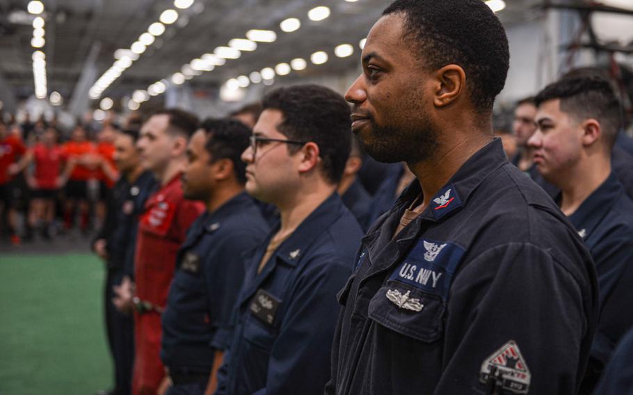 Damage Controlman 3rd Class Tyler Dance, from Inglewood, Calif., stands at ease during a re-enlistment ceremony in the hangar bay of the Nimitz-class aircraft carrier USS Harry S. Truman, Feb. 27, 2022. The Harry S. Truman Carrier Strike Group is on a scheduled deployment in the U.S. Sixth Fleet area of operations in support of U.S., allied and partner interests in Europe and Africa.