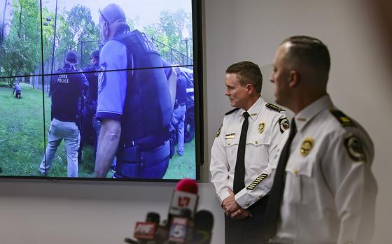 Cobb County Police Chief Stuart VanHoozer, left, and Captain Darin Hull watch video of the arrest of the Midtown shooter during a news conference at Cobb County Police Headquarters on Tuesday. (Natrice Miller/The Atlanta Journal-Constitution/TNS)