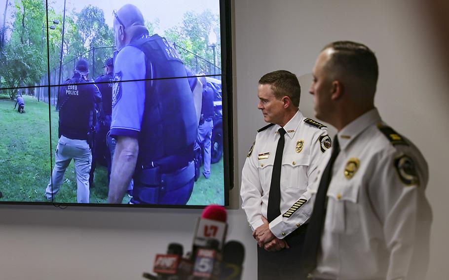 Cobb County Police Chief Stuart VanHoozer, left, and Captain Darin Hull watch video of the arrest of the Midtown shooter during a news conference at Cobb County Police Headquarters on Tuesday, May 16, 2023. 