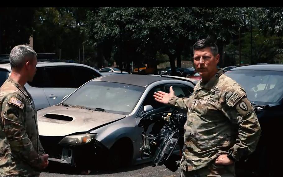 Maj. Gen. Joe Ryan, right, commander of U.S. Army Garrison Hawaii, and Command Sgt. Maj. Robert Haynie point out derelict cars abandoned by soldiers in a resale lot at Schofield Barracks, Hawaii, in this screenshot from a Facebook video posted May 9, 2022.