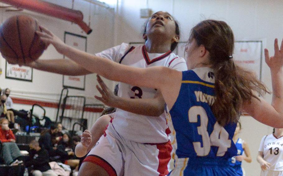 E.J. King's Moa Best drives to the basket against Yokota's Kayla Bogdan during Friday's semifinal in the DODEA-Japan girls basketball tournament. The Cobras won 51-13 and will face Nile C. Kinnick in Saturday's final.