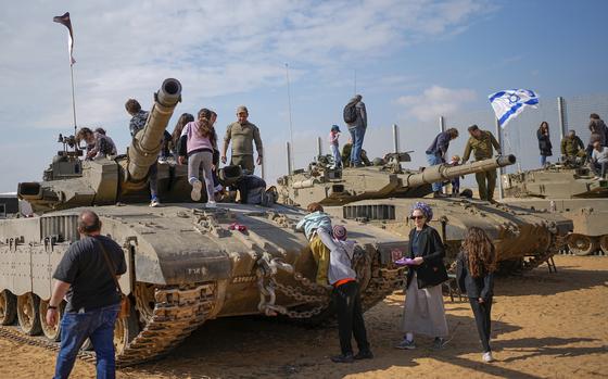 Israelis stand on tanks during an event for families of reservists outside a military base in southern Israel, Tuesday, Feb. 27, 2024. Israel and Hamas are inching toward a new deal that would free some of the roughly 130 hostages held in the Gaza Strip in exchange for a weeks-long pause in the war, now in its fifth month. A deal would bring some respite to desperate people in Gaza, who have borne a staggering toll in the war, as well as to the anguished families of hostages taken during Hamas' Oct. 7 attack that sparked the war.