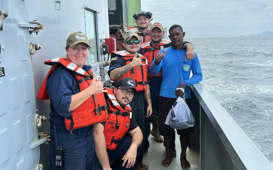 The crew of the USAV Palo Alto pose with an Indonesian fisherman they rescued near Obi Island, Indonesia, Sept. 1, 2023. He was found clinging to the lid of a cooler.  