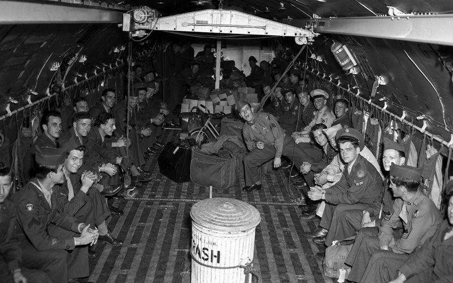 A black and white photo of men in an airplane.
