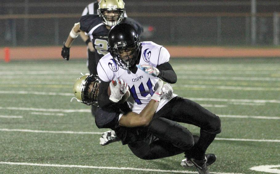 Osan's Jaylon Grant gets dragged down by Humphreys' Manny Lawson.