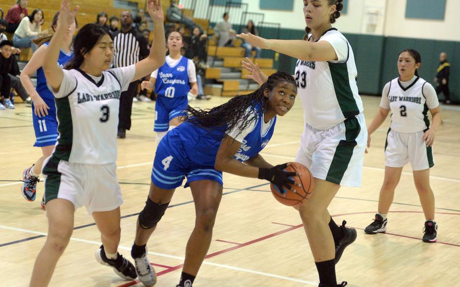 Osan's Tatiana Lunn weaves between Daegu's Gianna Tak and Jasmine Harvey during Friday's Korea girls basketball game. The Warriors won 28-17.