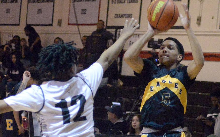 Robert D. Edgren's Dominique Waters shoots over Zama's Casey Stewart during Friday's DODEA-Japan boys basketball game. The Trojans won 61-37.