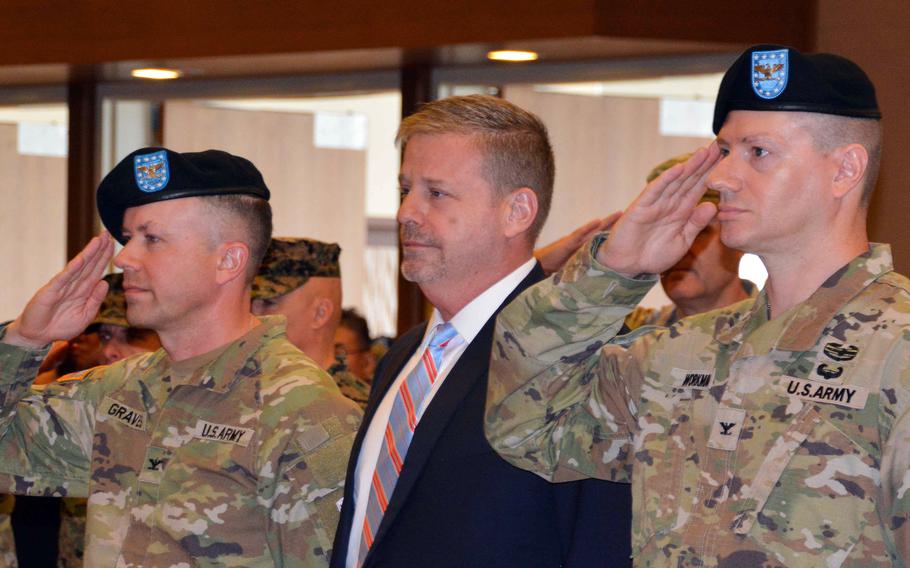 Army Col. Seth Graves, left, Camp Humphreys' outgoing commander; Craig Deatrick, director of Installation Management Command-Pacific; and Col. Ryan Workman, the garrison's incoming commander, take part in their change-of-command ceremony at the Morning Calm Center on the base south of Seoul, South Korea, Tuesday, July 11, 2023. 