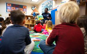 Lenese Rogers reads a story to children at Peterson Space Force Base, Colo., in November 2023. The military needs to better track the effectiveness of efforts to retain workers at base child care facilities, the Government Accountability Office said in a report released May 14, 2024.