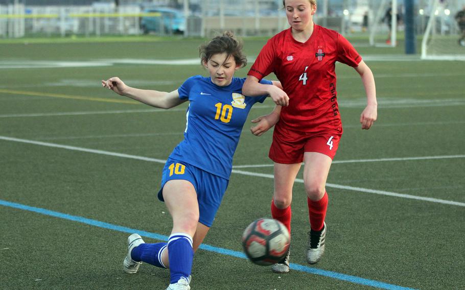 Yokota's Lucy Wellons boots the ball past Nile C. Kinnick's Ainslie Rochholz during Tuesday's DODEA-Japan/Kanto Plain girls soccer match. The Red Devils won 5-0 to remain unbeaten at 15-0.