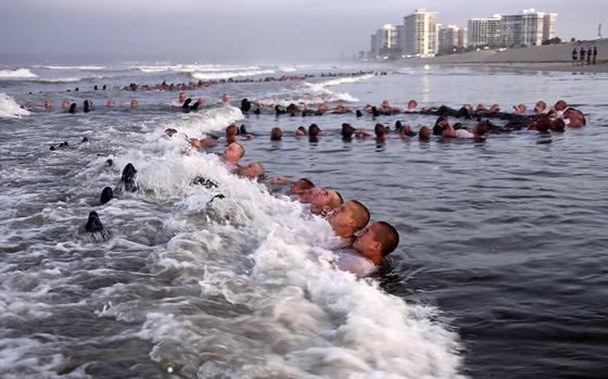 FILE - U.S. Navy SEAL candidates, participate in "surf immersion" during Basic Underwater Demolition/SEAL (BUD/S) training at the Naval Special Warfare (NSW) Center in Coronado, Calif., on May 4, 2020. The training program for Navy SEALs is plagued by widespread medical failures, poor oversight and the use of performance enhancing drugs that have increased the risk of injury and death to candidates seeking to become an elite commando, according to a highly critical new investigation triggered by the death of SEAL candidate Kyle Mullen. (MC1 Anthony Walker/U.S. Navy via AP, File)