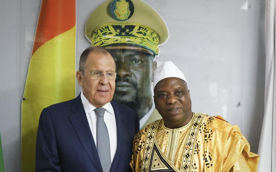 Russian Foreign Minister Sergey Lavrov, left, and Guinea’s foreign minister Morissanda Kouyate pose for a photo near a portrait of Guinea’s President Mamadi Doumbouya during their meeting in Conakry, Guinea, Monday, June 3, 2024.