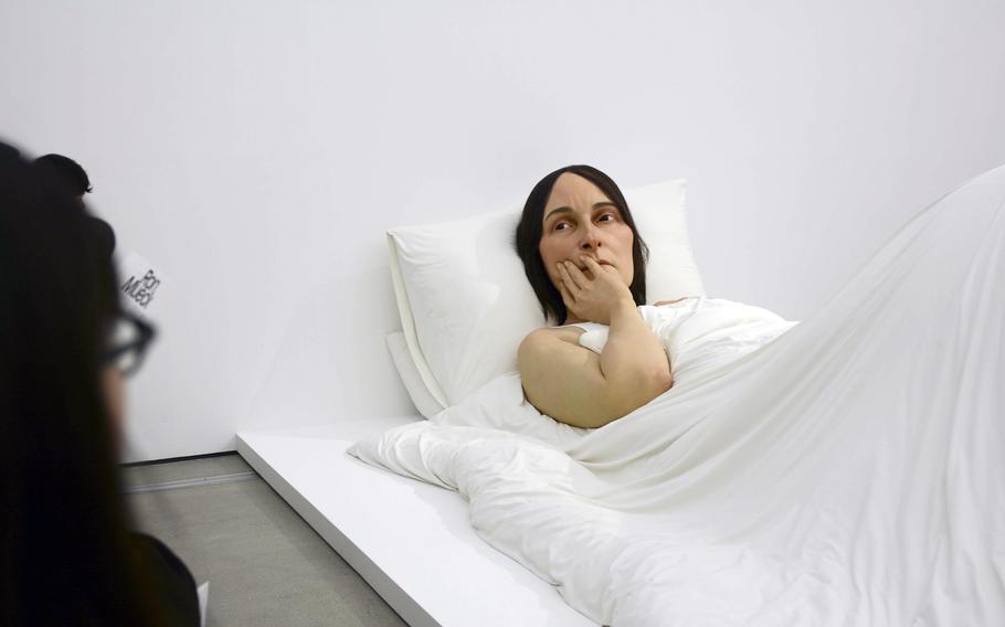 A visitor examines "In Bed" during Ron Mueck’s solo exhibition at the National Museum of Modern and Contemporary Art in Seoul, South Korea.