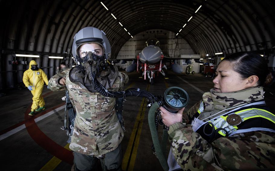 Tech. Sgt. Marianne Hebreo inspects a mask filter assembly worn by Airman 1st Class Eric Decker during exercise Radiant Falcon on April 24, 2024, at Spangdahlem Air Base, Germany.