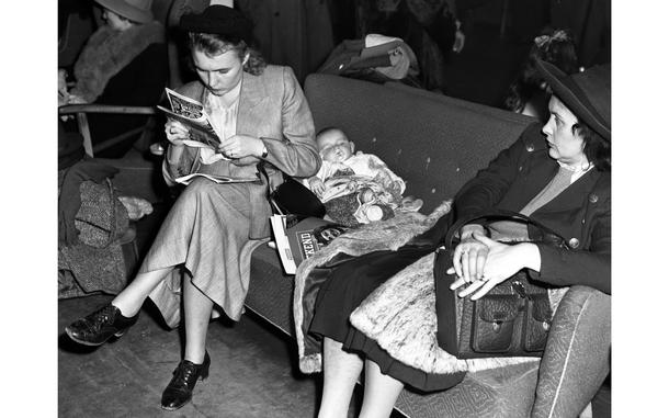 Frankfurt, Germany, October, 1948: Mrs. Oliver Johnson, left, a war bride married to an American sergeant, reads a magazine while son William snoozes on the sofa at the Rhein-Main airport. Between 50 and 75 war brides — some with their families, others unaccompanied — were leaving from Rhein-Main for the U.S. each week in advance of a December 27, 1948 deadline, after which immigration would become much more difficult.

Looking for Stars and Stripes’ historic coverage? Subscribe to Stars and Stripes’ historic newspaper archive! We have digitized our 1948-1999 European and Pacific editions, as well as several of our WWII editions and made them available online through https://starsandstripes.newspaperarchive.com/

META TAGS: War brides; WWII; Cold War; dependents; immigration