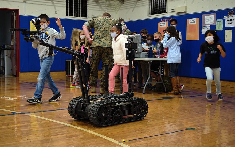 Lanham Elementary School students observe and control a robot used by a Marine Corps explosive ordnance teams during a STEAM event at Naval Air Facility Atsugi, Japan, May 27, 2021.