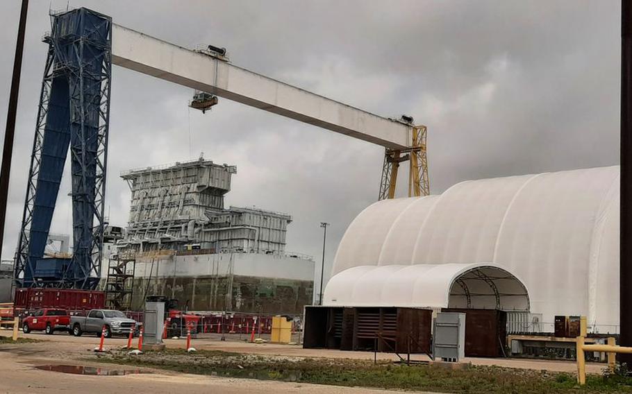 In June 2021, a Navy barge used in dockside nuclear refueling operations arrived in Mobile to be dismantled. The company handling the multimillion-dollar job has announced that work is complete. The barge, at left is positioned on land at a large crane used to lower sections as they are cut off. Inside the white enclosure at right, the large sections are broken down for recycling or disposal.