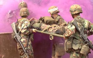 Hed: Expert Field Medical Badge, Kosovo ed., 2002

Camp Bondsteel, Kosovo, Aug. 24, 2002: Medical personnel transport an "injured" soldier through an obstacle course Aug. 22, 2002. As Staff Sgt. Jose Nuques emerges from the smoke, he helps his team carry a patient over a wall. Pictured from left to right are: 1st Lt. Stephanie Martinson, Pfc. Melanie Bauguess (white stripe on helmet) and Staff Sgt. Genaro Silvas. The four were among more than 130 soldiers who attempted to earn the prestigious badge, the first time it has been available to medics and other medical personnel deployed to Kosovo. Om average, only about 15 - 20 percent of each class makes it. 

Read the full account by Kevin Dougherty here. 