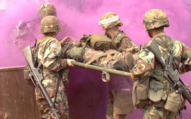 Hed: Expert Field Medical Badge, Kosovo ed., 2002

Camp Bondsteel, Kosovo, Aug. 24, 2002: Medical personnel transport an "injured" soldier through an obstacle course Aug. 22, 2002. As Staff Sgt. Jose Nuques emerges from the smoke, he helps his team carry a patient over a wall. Pictured from left to right are: 1st Lt. Stephanie Martinson, Pfc. Melanie Bauguess (white stripe on helmet) and Staff Sgt. Genaro Silvas. The four were among more than 130 soldiers who attempted to earn the prestigious badge, the first time it has been available to medics and other medical personnel deployed to Kosovo. Om average, only about 15 - 20 percent of each class makes it. 

Read the full account by Kevin Dougherty here. 