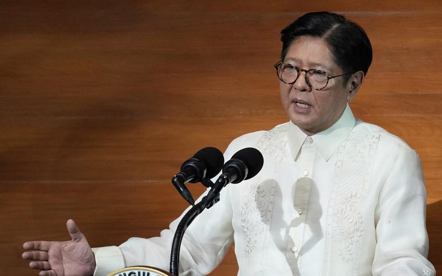 The Philippine president speaks into a microphone while he gestures with a hand.