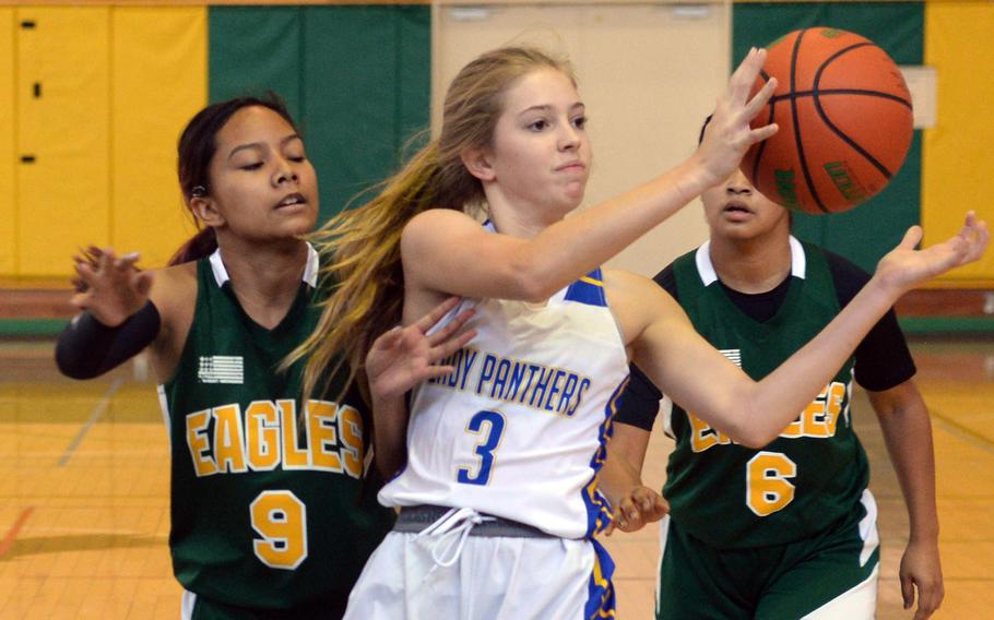 Yokota's Charlotte Rhyne looks to pass between Robert D. Edgren's Maliyah Magat and Zalea Washington during Saturday's DODEA-Japan basketball game. The Panthers won 30-13.