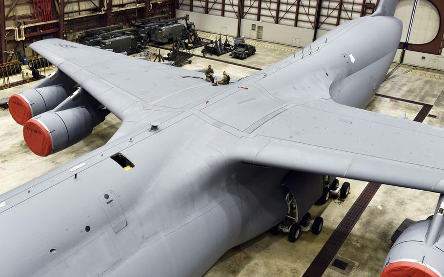 United States Air Reserve Master Sgt. Anthony Botass and Tech Sgt. Joshua Newman work on the aileron of a C-5M in a maintenance hangar at Westover Air Reserve Base in Chicopee, Mass. 