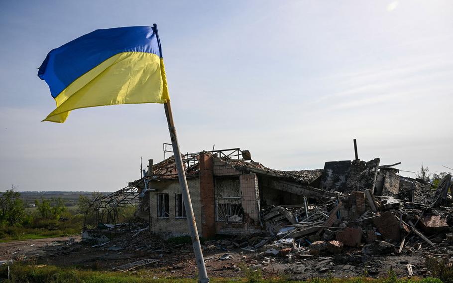 A Ukrainian national flag is displayed in front of a destroyed house near Izium, eastern Ukraine, on Saturday, Oct. 1, 2022, amid the Russian invasion of Ukraine.
