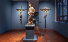 Donatello's early statue of a clothed David in front of two crucifixes made from painted wood, the one on the left by Donatello, the one on the right by Filippo Brunelleschi. 