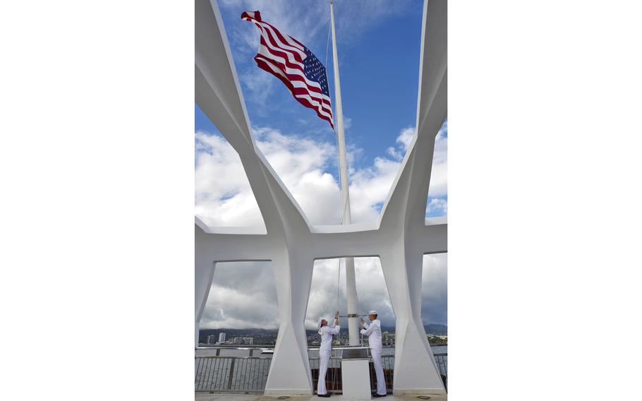 Electronics Technician 3rd Class Timothy Crossno (left) and Cryptologic Technician Interpretive 3rd Class Adam Crist perform evening colors in 2014 at the USS Arizona Memorial at Pearl Harbor, Hawaii. 