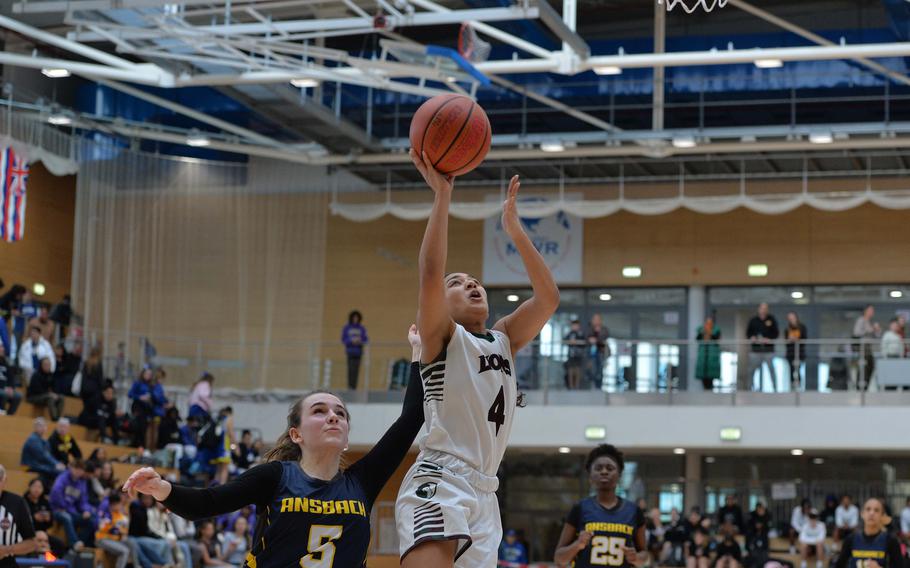 AFNORTH’s Madelyn Hatfield gets past Ansbach’s Annika Asbury for a basket in the Lions’ 34-23 win over Ansbach in the girls Division III final at the DODEA-Europe basketball championships in Wiesbaden, Germany, Feb. 17, 2024.