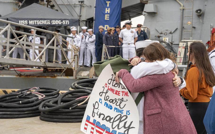 A sailor assigned to the destroyer USS Mitscher embraces his wife after the ship's return to Naval Station Norfolk, Va., April 16, 2022. Mitscher and USS The Sullivans deployed to Europe earlier this year as tensions rose in Ukraine. They returned to their U.S.-based homeports in the last few days, officials said.  