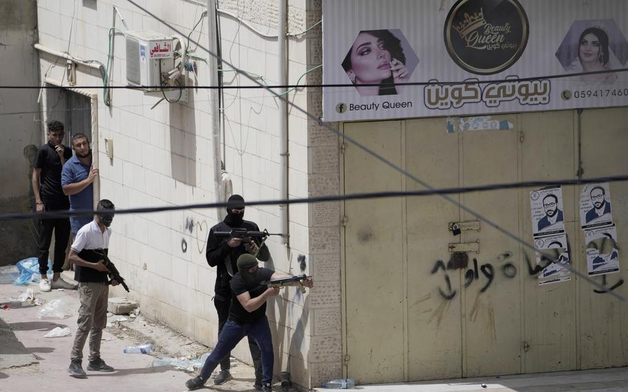 Palestinian gunmen take aim during an Israeli military operation in the West Bank town of Jenin, Friday, May 13, 2022. Israeli troops pushed into Jenin early Friday following the death of veteran Al Jazeera correspondent Shireen Abu Akleh on Wednesday when she was shot dead by Israeli forces while covering a military operation in the occupied West Bank.