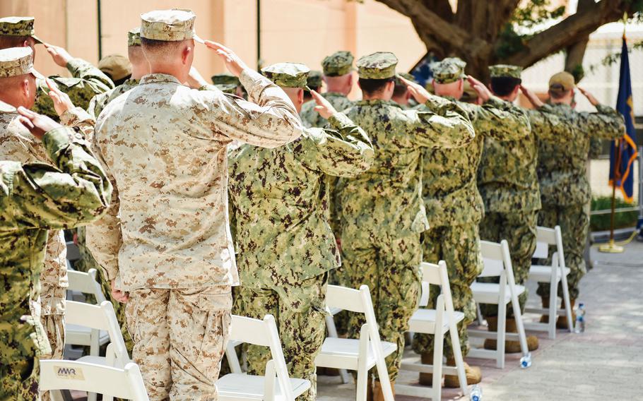 Sailors and Marines salute at a memorial service Wednesday, April 24, 2024, at Naval Support Activity Bahrain, in honor of three USS Firebolt service members killed in a 2004 attack.