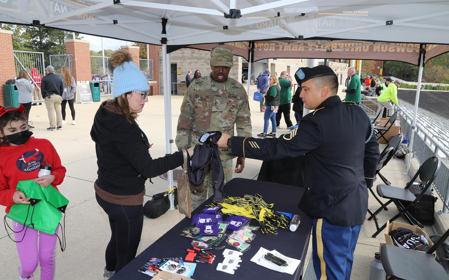Army Staff Sgt. Jesse Cerda hands out merchandise in Towson, Md., on Oct. 30, 2021. Army recruiters now have additional offers for potential recruits, including increased incentive cash bonuses and assignment selection.