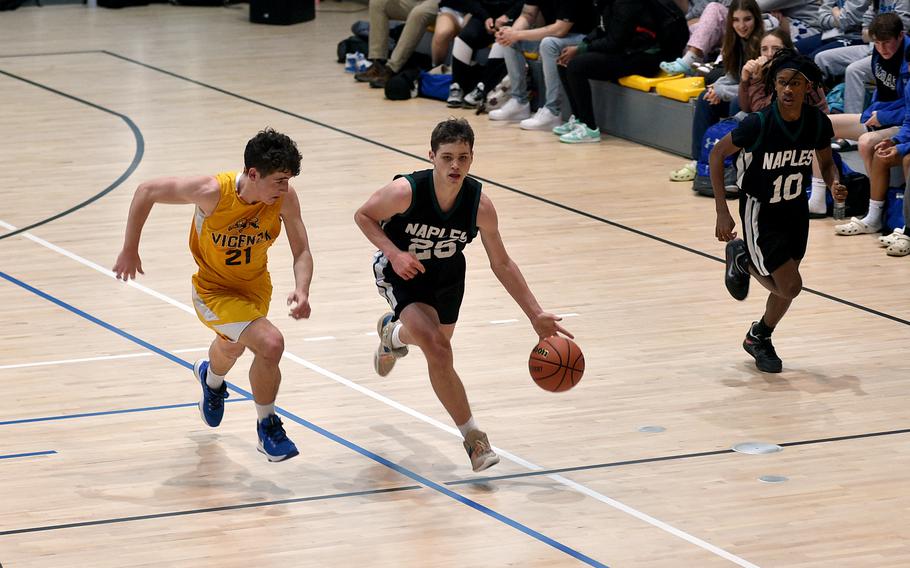 Naples' Patrick Fraim dribbles on the fast break while Vicenza's Jayden Steimle defends during pool play of the Division II DODEA European Basketball Championships on Thursday at Southside Fitness Center on Ramstein Air Base, Germany. Trailing is the Wildcats' Jeramiah Robinson, right.