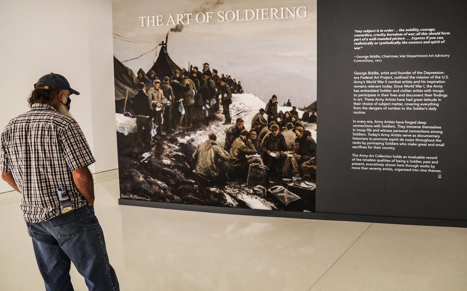 A visitor reads the introduction to the Art of Soldiering exhibit at the National Museum of the United States Army on its reopening day, June 14, 2021.