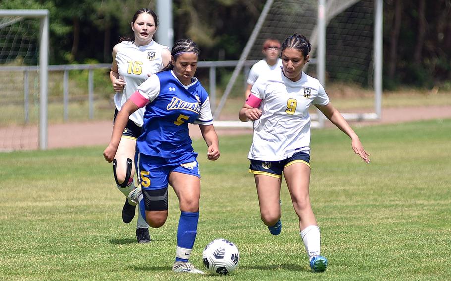 Sigonella striker Charlize Caro and Ansbach defender Abigail Castillo chase after the ball during the second day of round-robin action at the 2025 Division III DODEA European championships on May 20, 2025, at Rothenborn Stadion in Landstuhl, Germany.