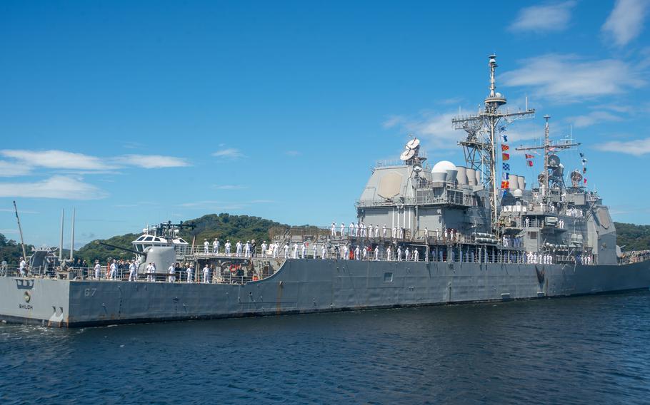 Crew members of the guided-missile destroyer USS Shiloh man the rails as the ship departs Yokosuka Naval Base, Japan, for Pearl Harbor, Hawaii, on Sept. 5, 2023. 