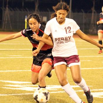 E.J. King's Fernanda Diaz and Matthew C. Perry's Soledad Arce scrum for the ball during Friday's DODEA-Japan soccer match. The teams played to a 1-1 draw.