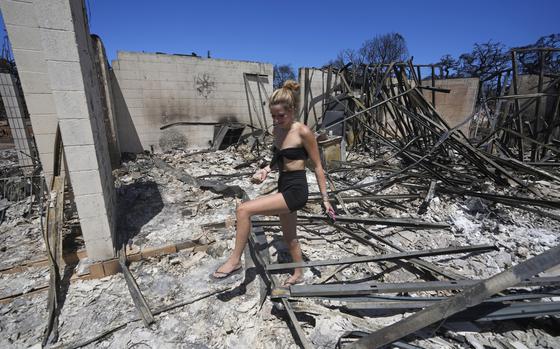 FILE - Sydney Carney walks through her home, which was destroyed by a wildfire on Aug. 11, 2023, in Lahaina, Hawaii. Lahaina residents are grappling with a range of feelings as Maui authorities plan to begin allowing them back into what has become known as the "burn zone." (AP Photo/Rick Bowmer, File)