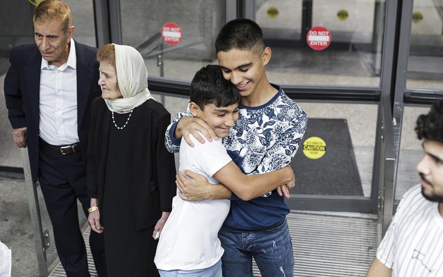 Masi Stanekzai embraces his younger brother Faisal at Dulles International Airport. The Stanekzais were among the hundreds of cases of Afghan families separated during the Kabul airport chaos more than a year ago. 