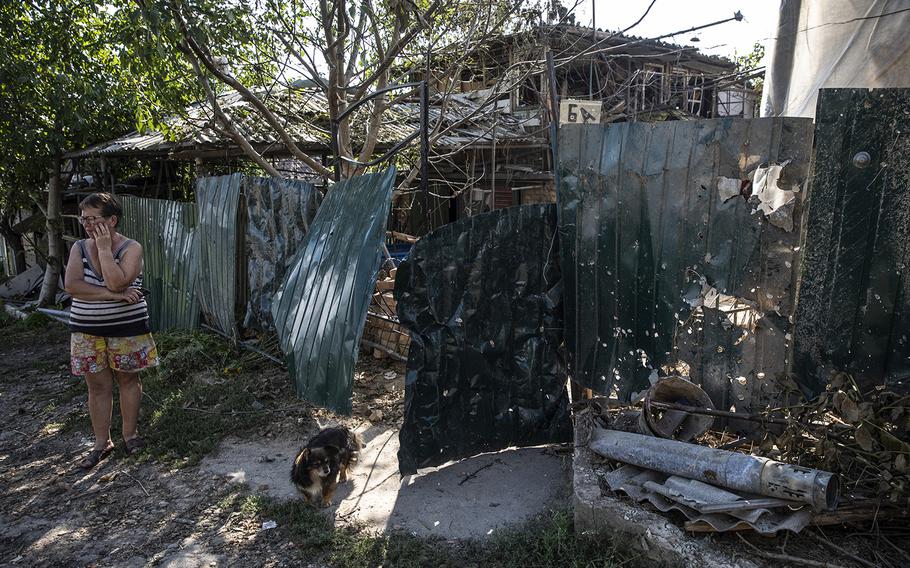 Kateryna Semenova, 65, outside her home in Nikopol, across the river from the Zaporizhzhia nuclear power plant, on Aug. 19, 2022. Her home had been damaged by a Russian rocket.