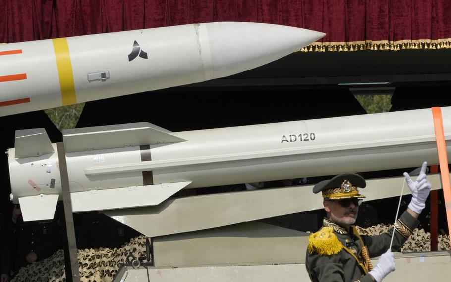 Missiles are carried on a truck as an Iranian army band leader conducts the music band during Army Day parade at a military base in northern Tehran, Iran, Wednesday, April 17, 2024. 