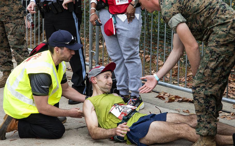 A runner is assisted at the finish line of the 48th Marine Corps Marathon on Sunday, Oct. 29, 2023, in Arlington, Va.