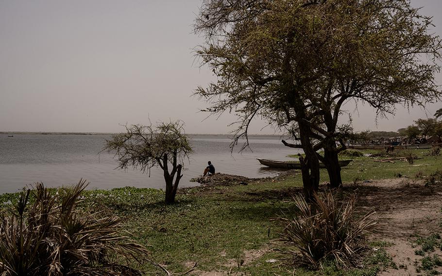 A man sits by the water in Koulkimé, by the side of Lake Chad, in Chad, on April 1, 2023. 