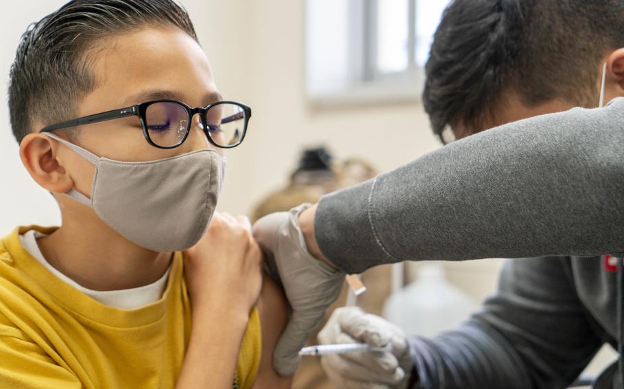 Hospitalman Chandler Story administers a Pfizer COVID-19 vaccination Nov. 16, 2021, to a DoD dependant at Sullivans Elementary School during a vaccination event for children aged 5-11 on Yokosuka Naval Base in Japan.